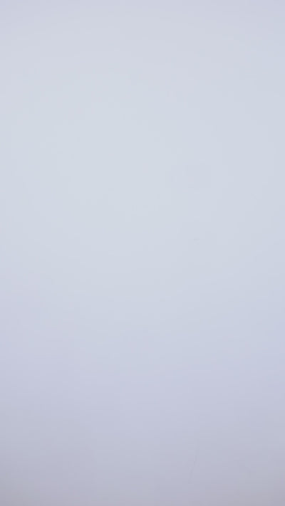 Modelo luciendo conjunto Onix de Giebelle - crop top negro con manga larga, escote corazón y fornitura plateada, combinado con legging acampanado de tejido brillante moldeador - Colección Invierno 2025